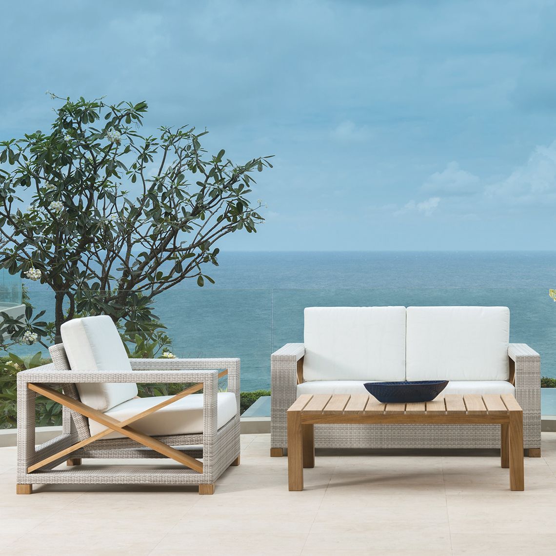 The Jupiter Lounge Chair combines contemporary angular design with hand-woven all-weather wicker and teak accents. Its floating seat deck creates visual lightness while providing comfortable outdoor seating. - alternate view