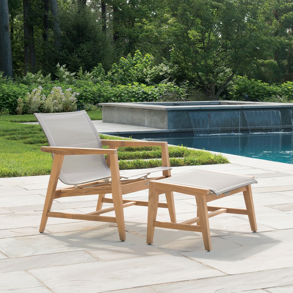 The Marin Club Ottoman brings mid-century modern elegance to outdoor spaces with Grade A teak construction and tapered legs. Its compact footprint and durable Batyline sling surface make it ideal for patios and covered porches. - alternate view