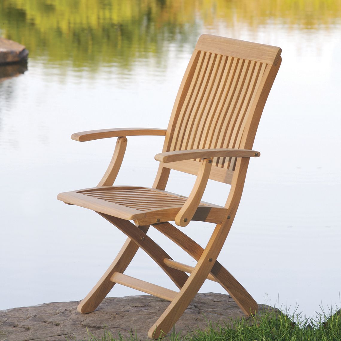 The Monterey Dining Armchair combines graceful curves with practical functionality. Crafted from solid Grade A teak, it's built to withstand diverse weather conditions while folding compactly for storage. - alternate view