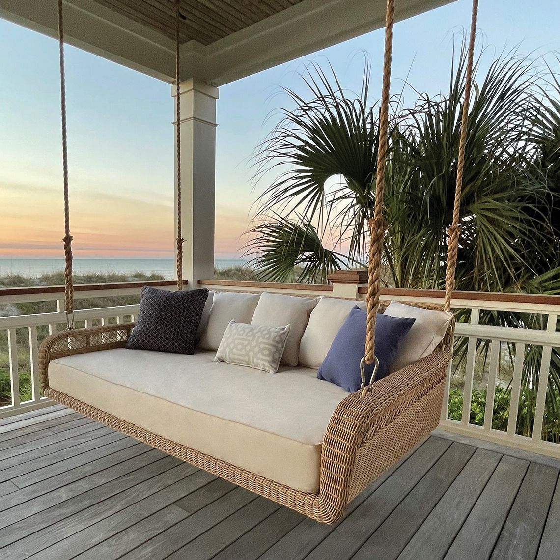 The Amelia Hanging Daybed transforms outdoor spaces into serene retreats with its hand-woven all-weather wicker construction. Designed to accommodate a standard twin mattress, it offers a unique suspended lounging experience. - alternate view
